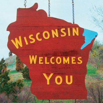 Text contains Wisconsin Welcomes You. Image contains state of Wisconsin shape over nature scene.