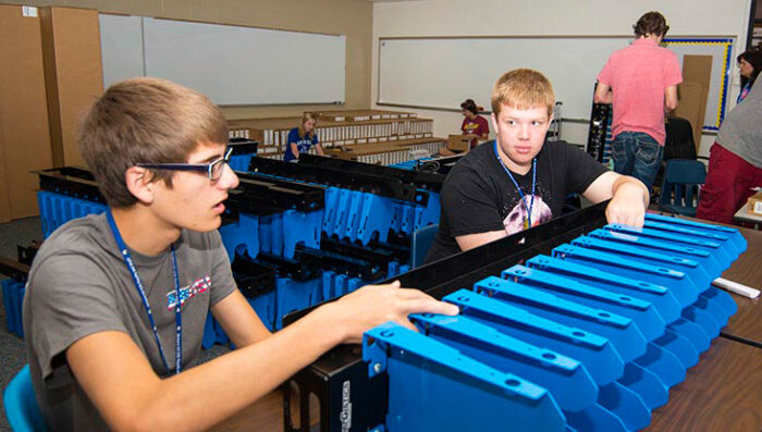 Image shows two students with a PowerGistics charging station.