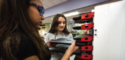 Image shows students taking Chromebook out of PowerGistics charging station.