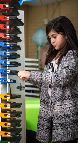 Image shows girl unplugging device that's in a PowerGistic charging station