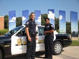 Images shows two Olathe police officers in front of police car