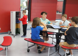 Image shows student retrieving device from PowerGistics Flex20 charging station in the lunchroom