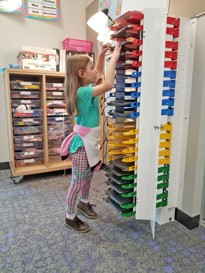 girl puts device in PowerGistics charging station